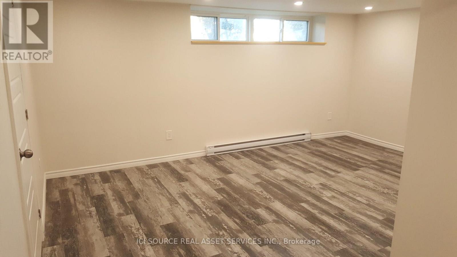 A room with a wooden floor and a window.