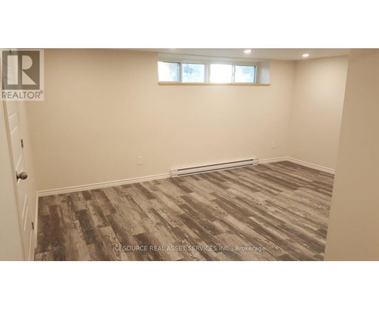 A room with a wooden floor and a window.