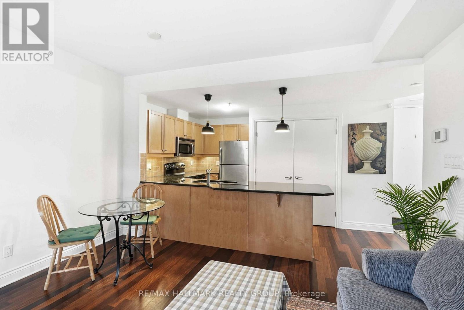A modern kitchen with wooden cabinets and a glass table.