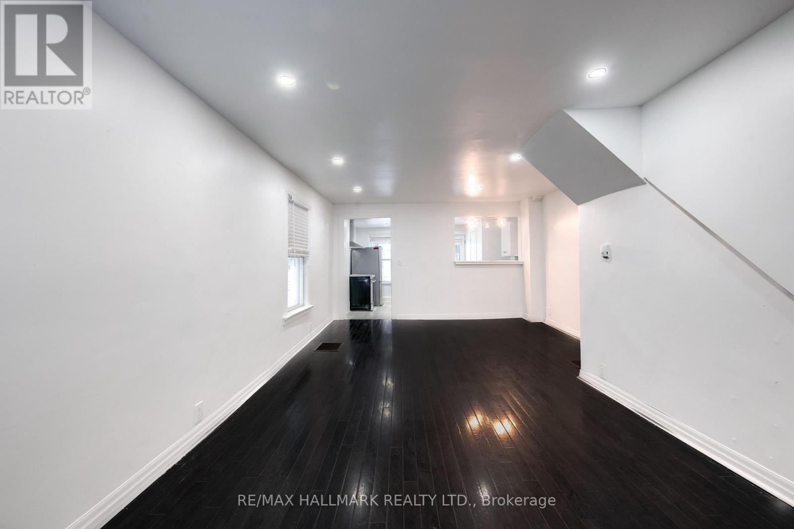 A spacious room with wooden floors and white walls.