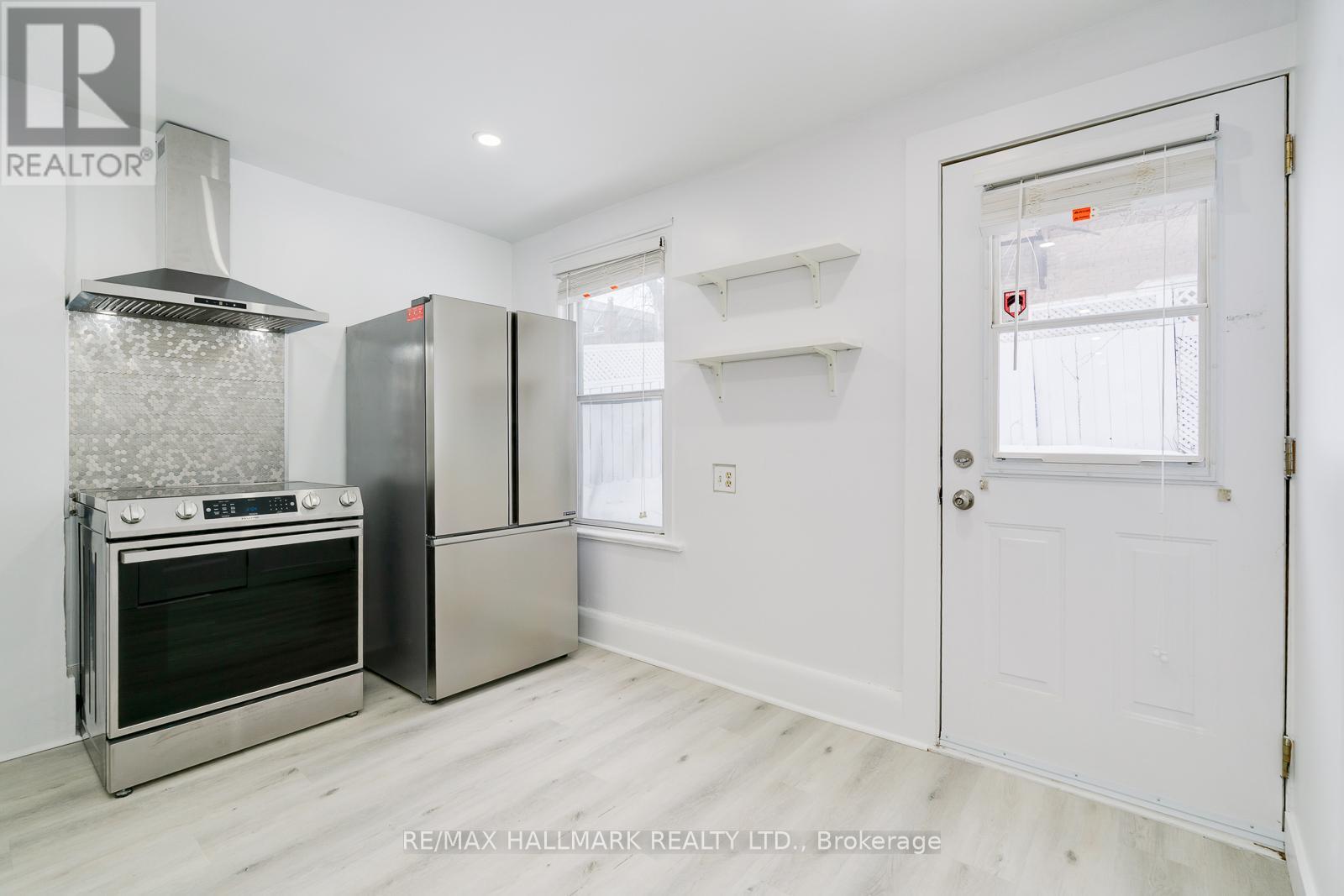A kitchen with a stainless steel oven and refrigerator.
