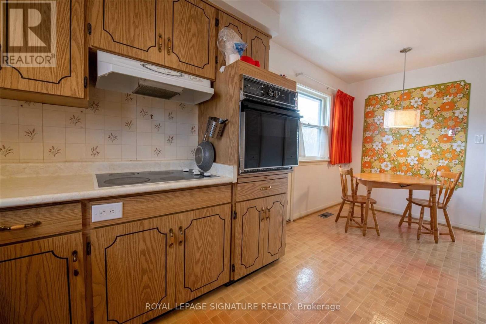 A kitchen with wooden cabinets and a tile backsplash.