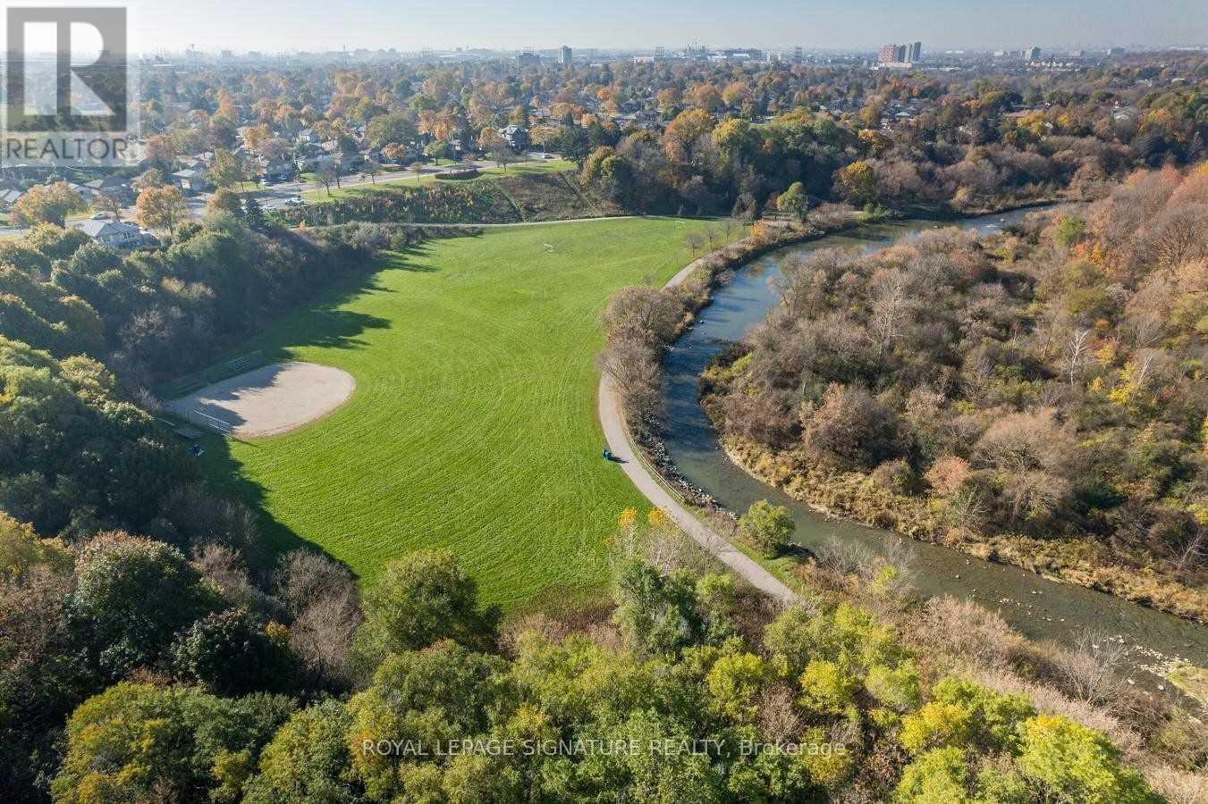 A river flows through a green valley with trees on the banks.
