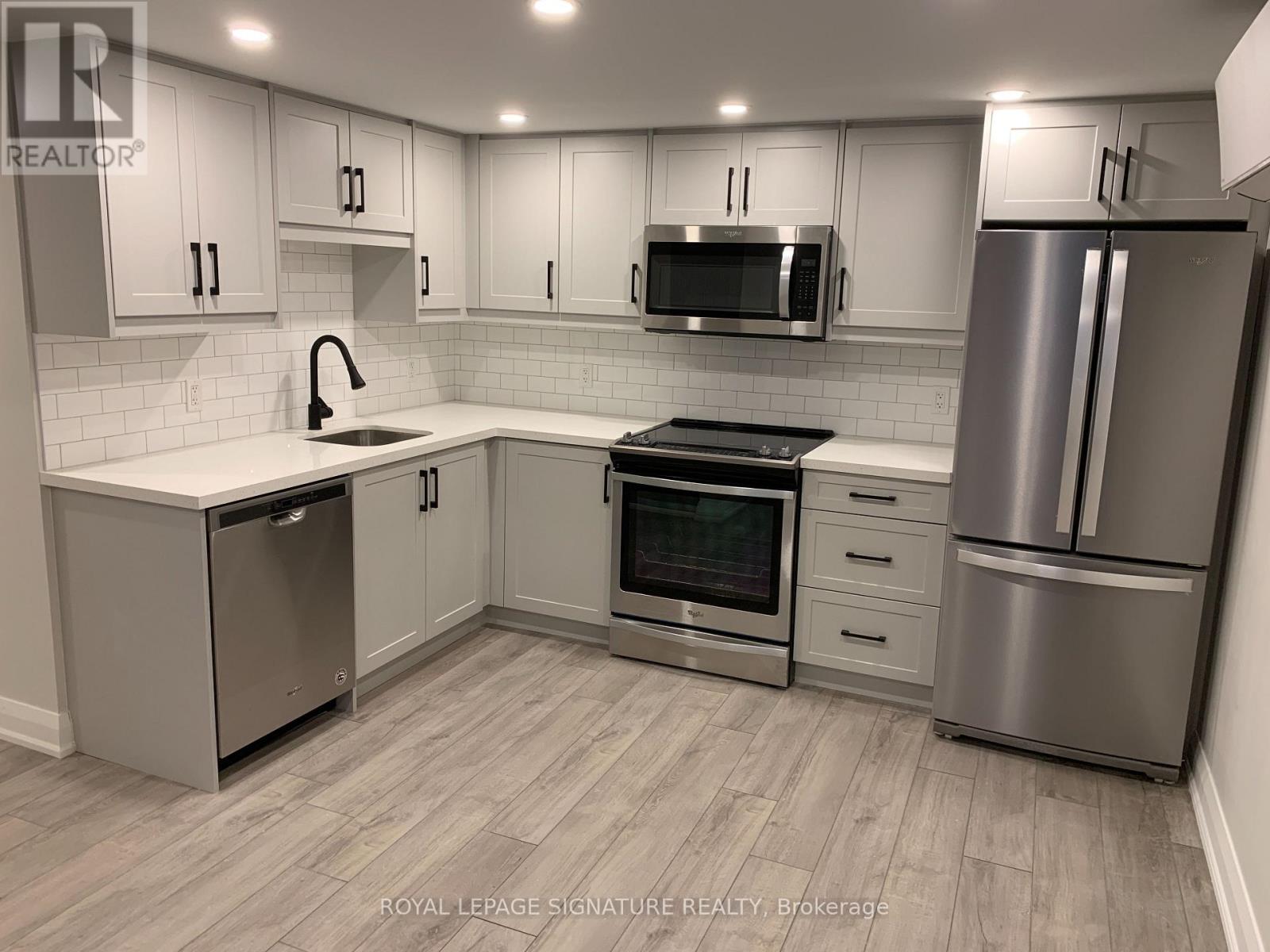 A kitchen with white cabinets and stainless steel appliances.
