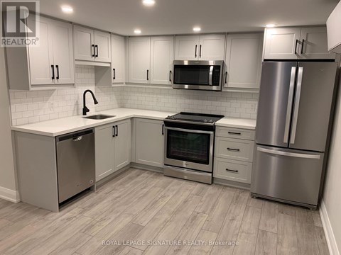 A kitchen with white cabinets and stainless steel appliances.