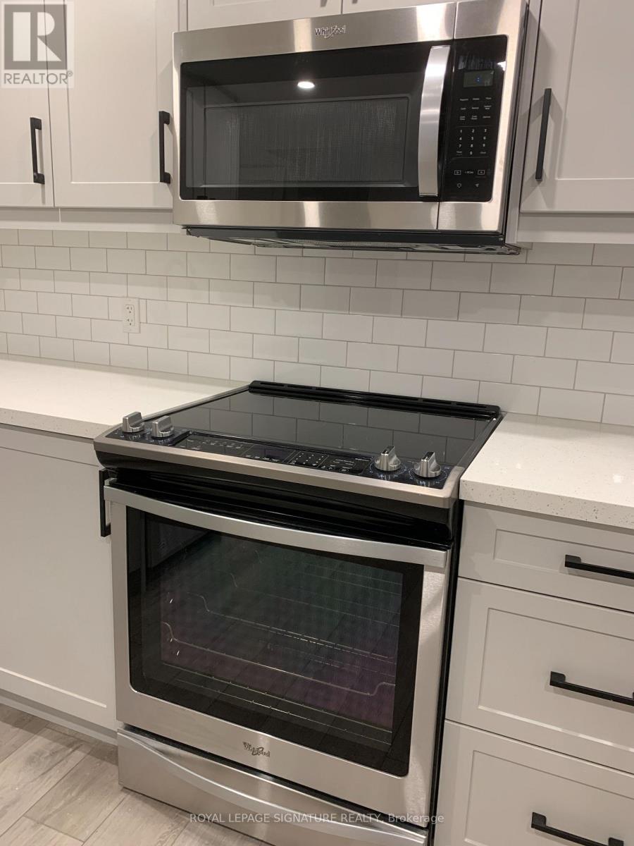A stainless steel oven with a glass door is in a kitchen.