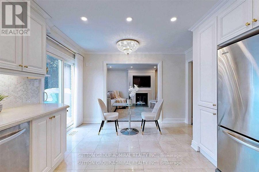 A kitchen with white cabinets and a dining table.