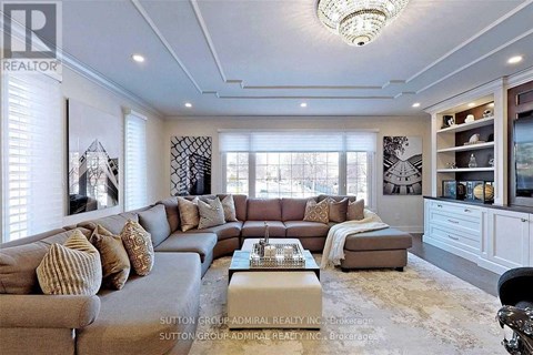A well-lit living room with a grey sofa and a coffee table.