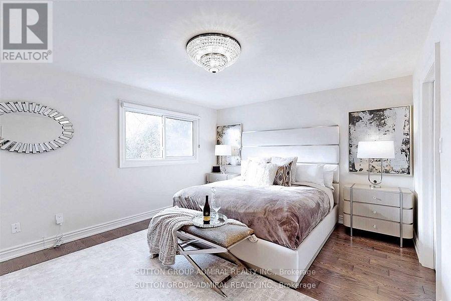 Bedroom with a bed, nightstand, and a mirror.