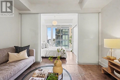 A living room with a grey couch and a coffee table in front of a sliding glass door.