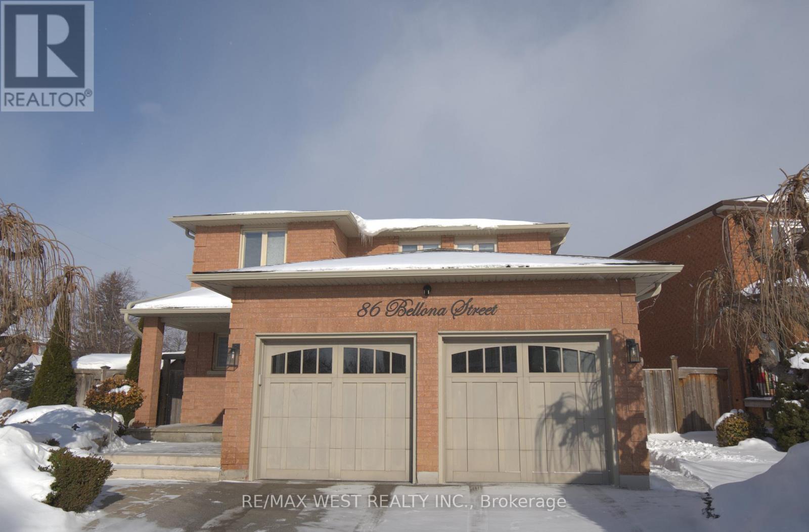 A house with a brown brick facade and a white garage door is shown.
