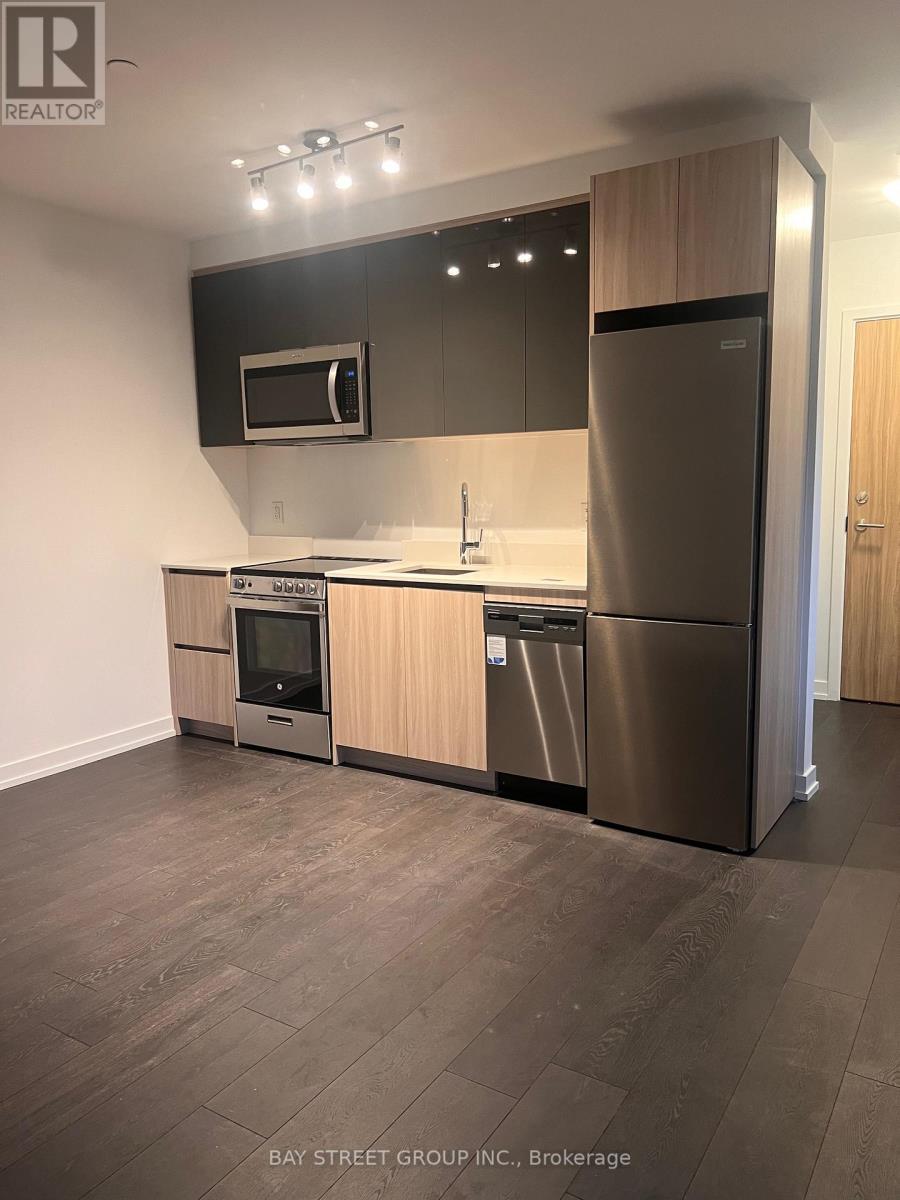 A modern kitchen with stainless steel appliances and wooden cabinets.