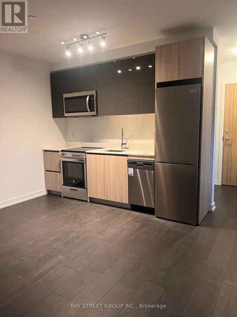 A modern kitchen with stainless steel appliances and wooden cabinets.
