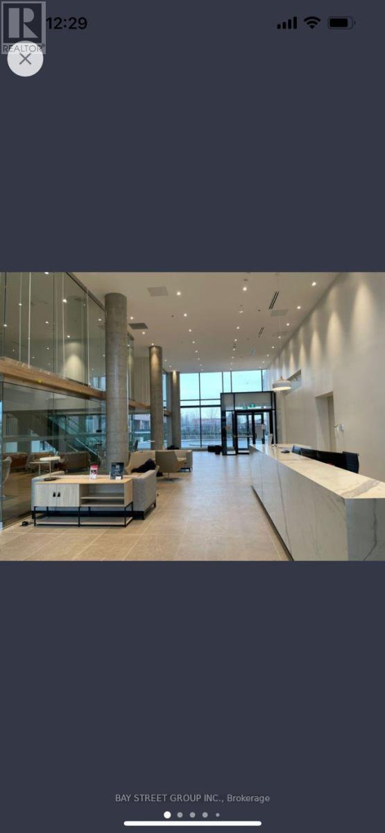 A modern office space with a reception desk and glass walls.