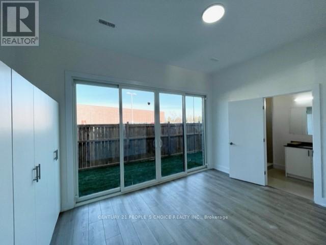 A spacious room with a sliding glass door leading to a backyard.