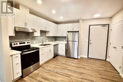 A kitchen with white cabinets and a wooden floor.