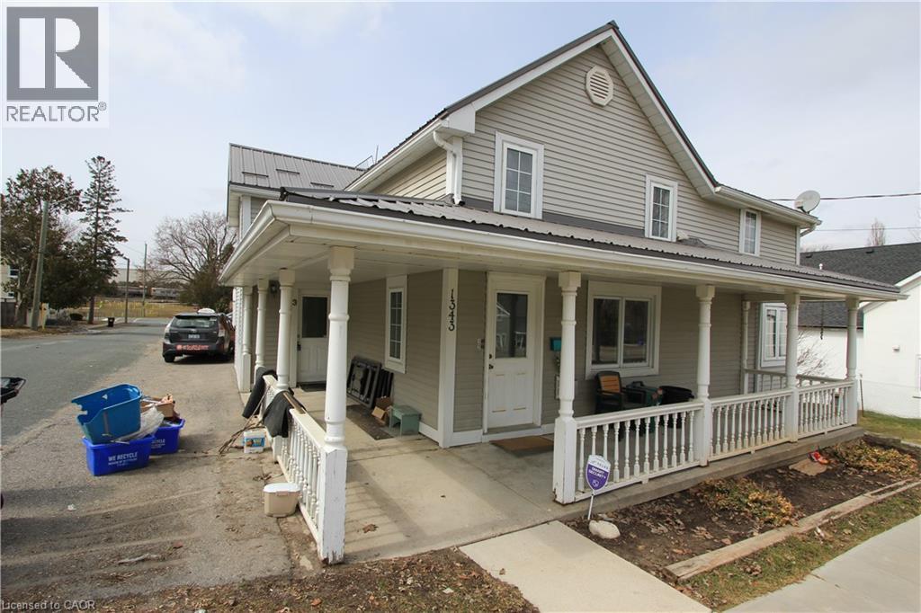 A house with a porch and a car parked in front.