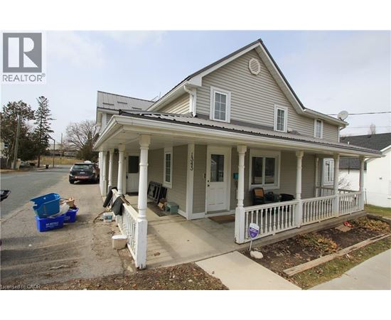 A house with a porch and a car parked in front.