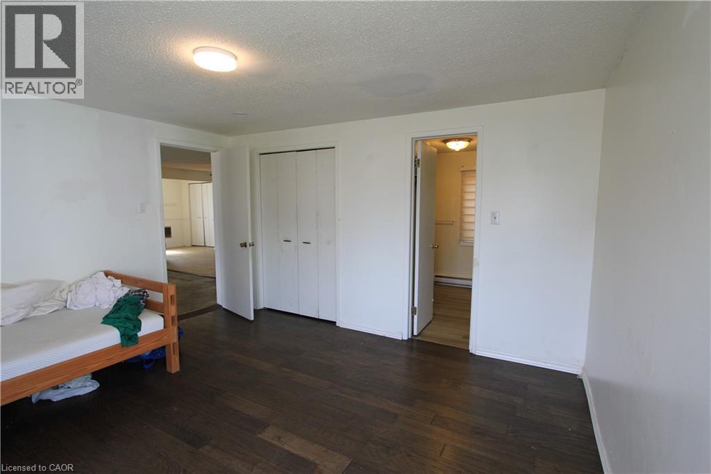 A bedroom with a bed and a wooden floor.