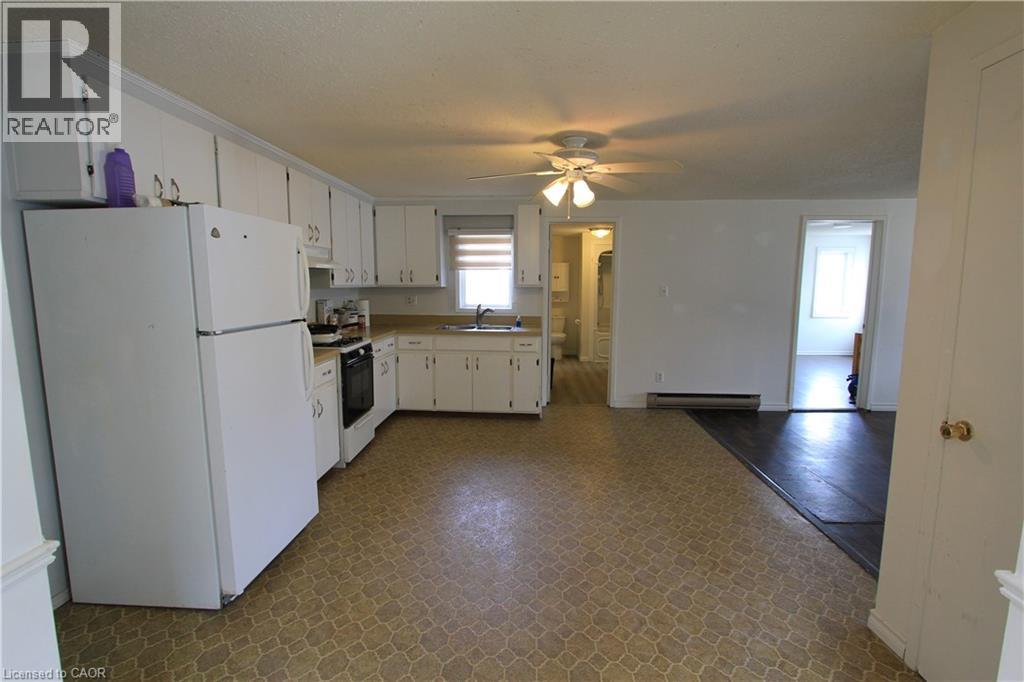 A kitchen with white cabinets and a refrigerator.