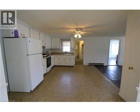 A kitchen with white cabinets and a refrigerator.