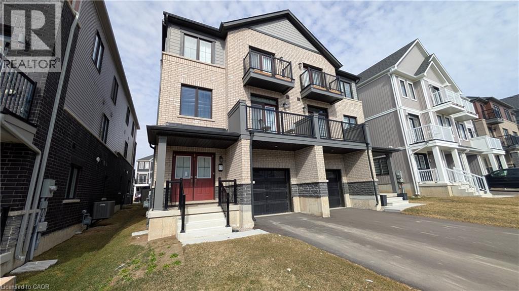 A row of modern townhouses with balconies and garages.