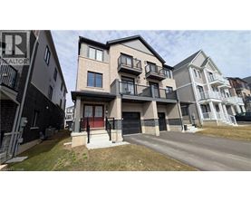 A row of modern townhouses with balconies and garages.
