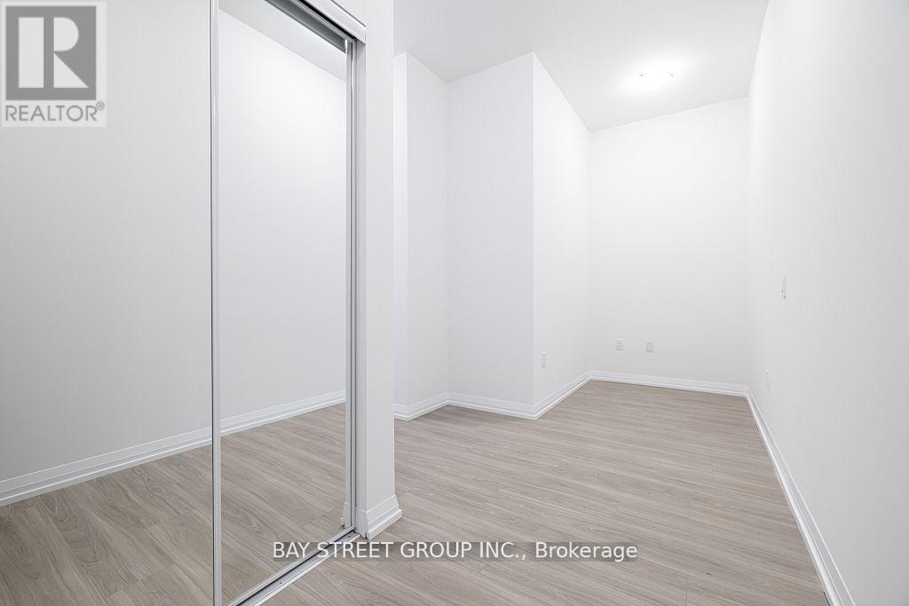 A white room with a door and a sign that says Bay Street Group, Brokerage.