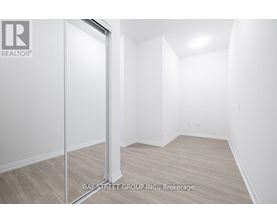 A white room with a door and a sign that says Bay Street Group, Brokerage.