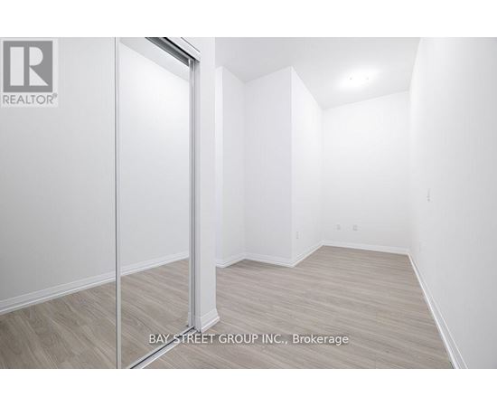 A white room with a door and a sign that says Bay Street Group, Brokerage.