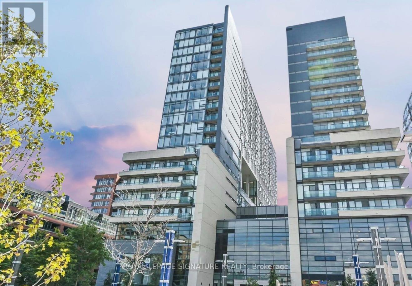 A cityscape with modern buildings and trees in the foreground.