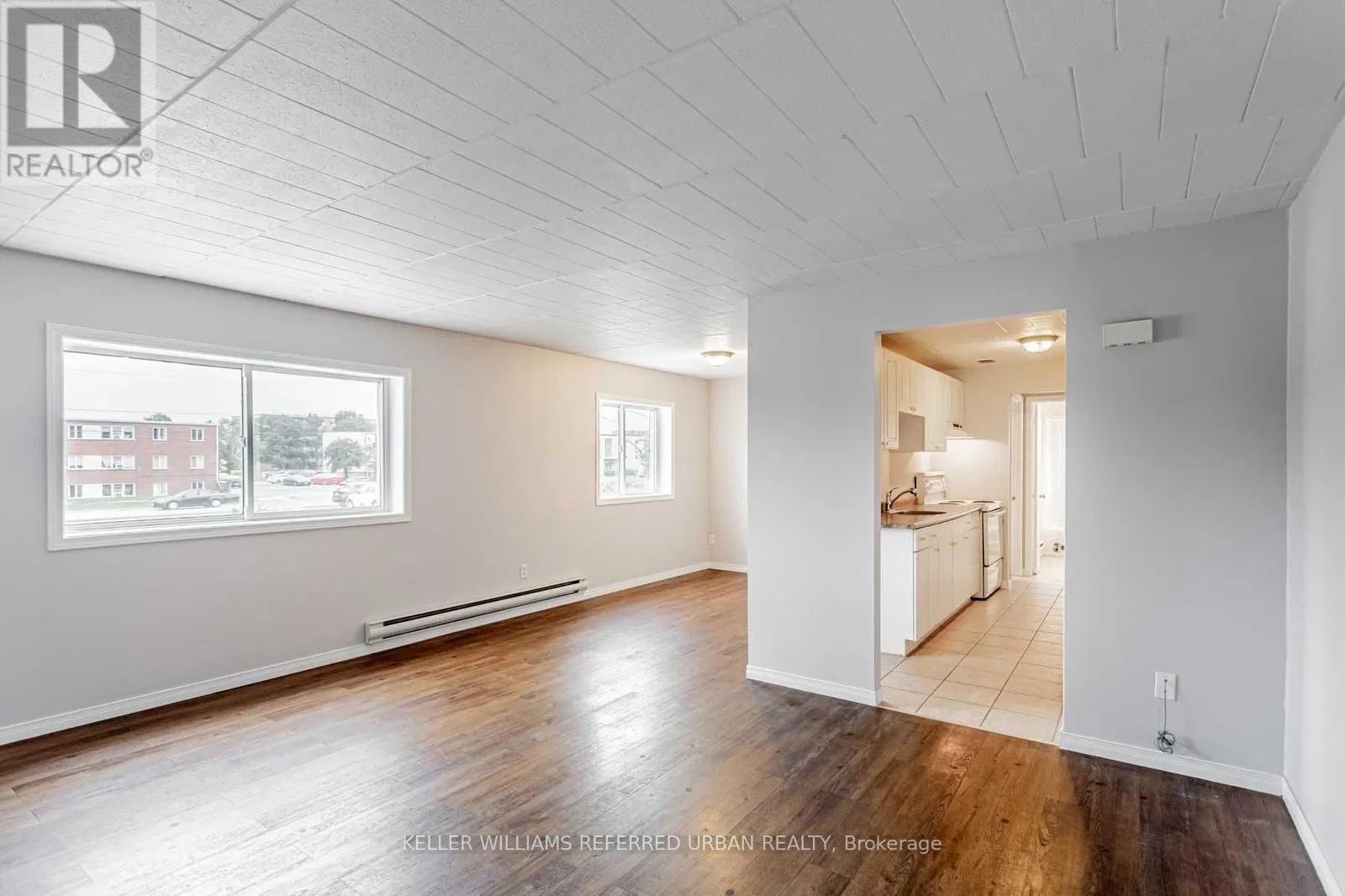 A spacious room with wooden floors and white walls.