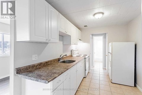 A kitchen with white cabinets and a granite countertop.