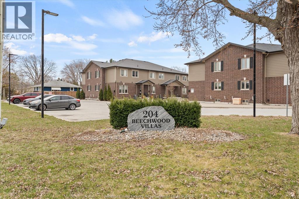 A real estate sign for Beechwood Villas in front of a building.