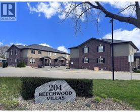 A real estate sign for Beechwood Villas in front of a building.