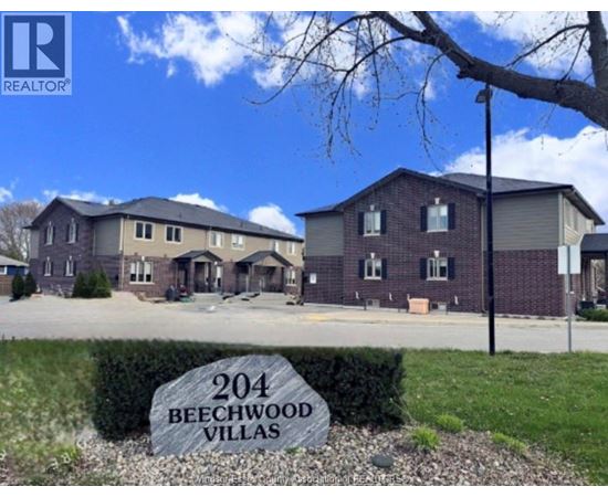A real estate sign for Beechwood Villas in front of a building.