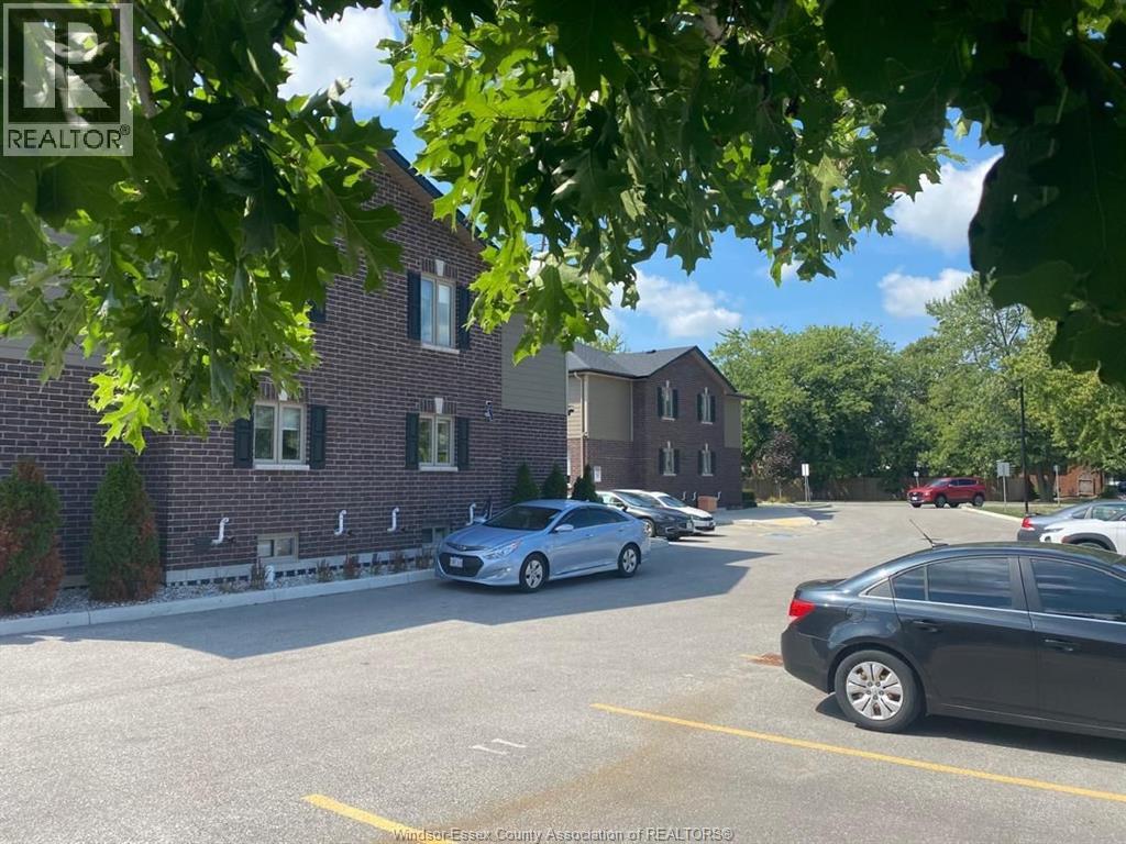 A parking lot with cars and a building in the background.
