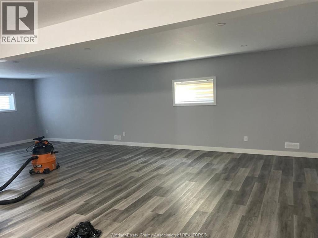 A room with a vacuum cleaner on the wooden floor.