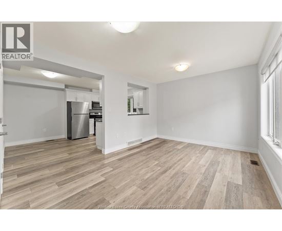 A room with a vacuum cleaner on the wooden floor.