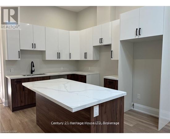 A kitchen with white cabinets and a white countertop.