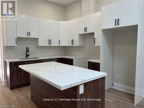 A kitchen with white cabinets and a white countertop.