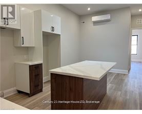 A kitchen area with a white countertop and wooden cabinets.