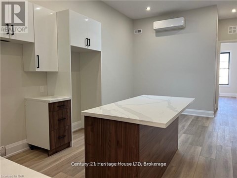 A kitchen area with a white countertop and wooden cabinets.