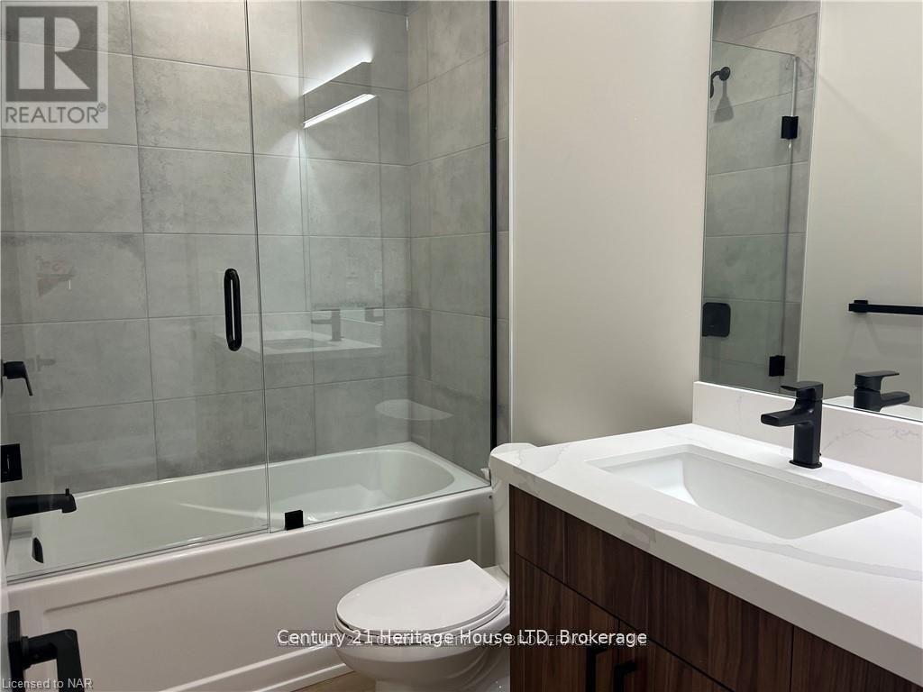 A bathroom with a sink, toilet and shower.