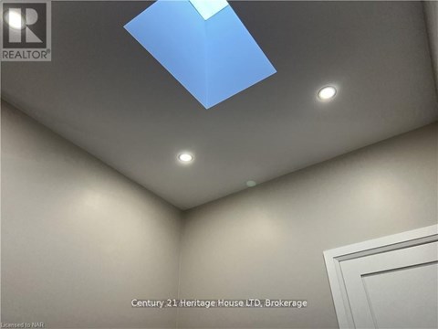 A room with a skylight and a white door.