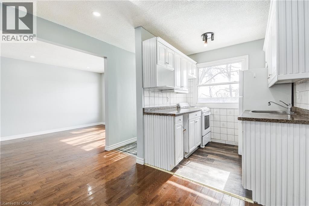 A kitchen with white cabinets and a wooden floor.