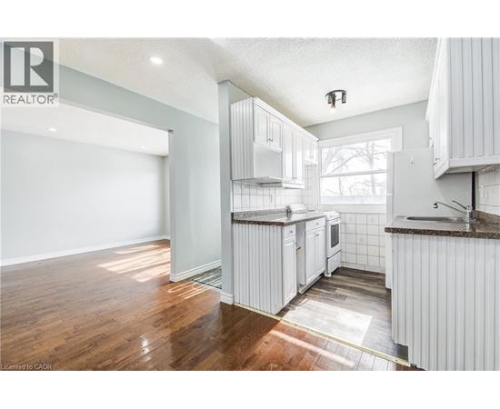 A kitchen with white cabinets and a wooden floor.