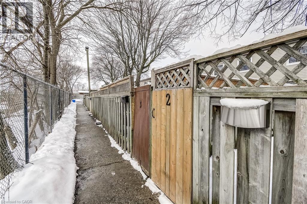 A snowy pathway with a fence and a sign that says 2.