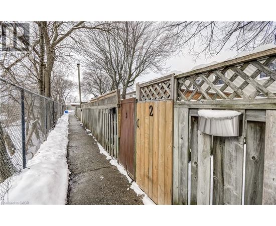 A snowy pathway with a fence and a sign that says 2.