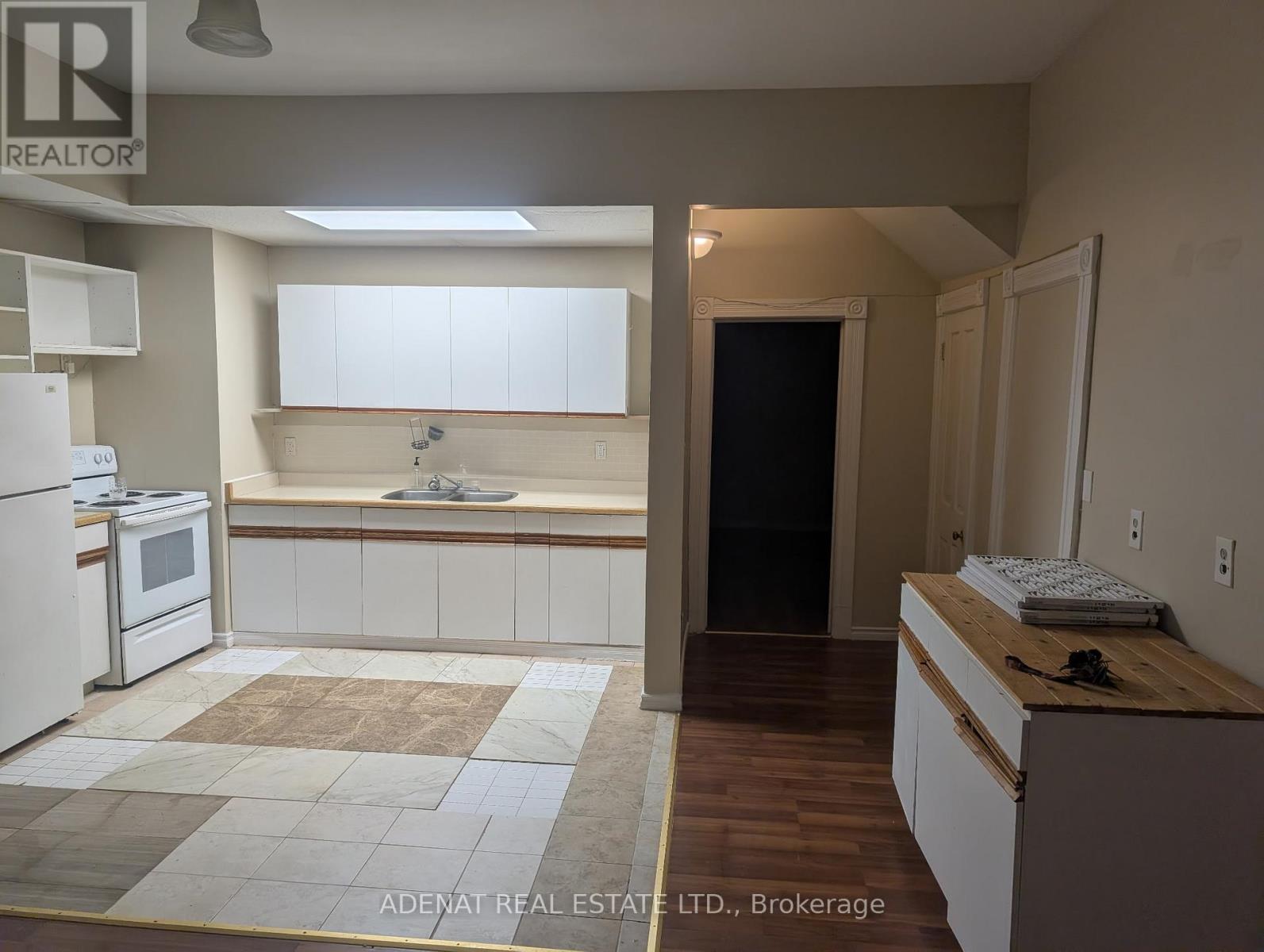 A kitchen with white appliances and a wooden counter.